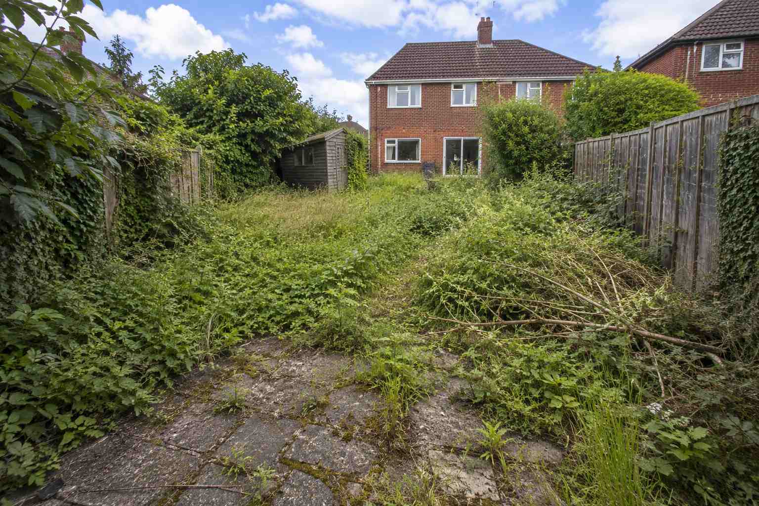 A beautifully landscaped garden with lawn, patio and planted borders in Surrey