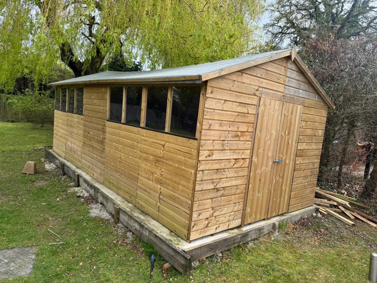 A newly built timber garden shed with a pitched roof and painted finish