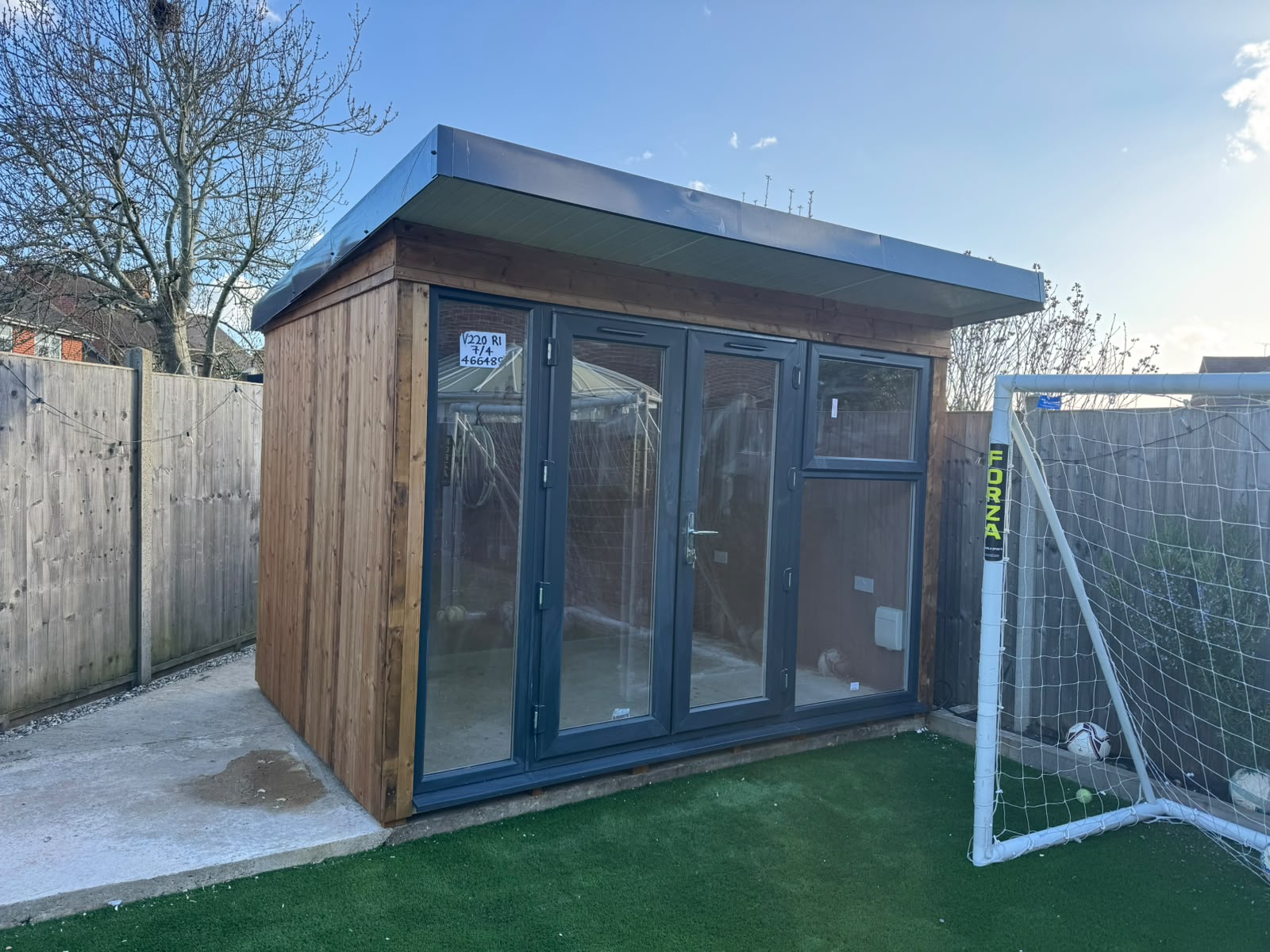 A newly installed timber summerhouse with a pitched roof and painted finish