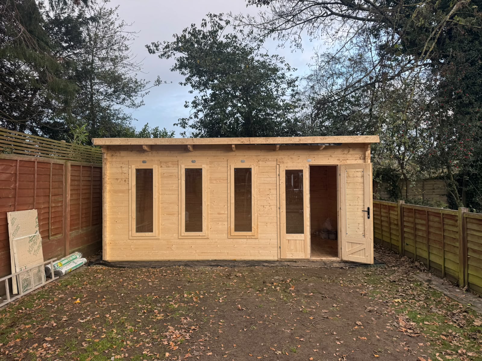 A newly installed timber summerhouse with a pitched roof and painted finish